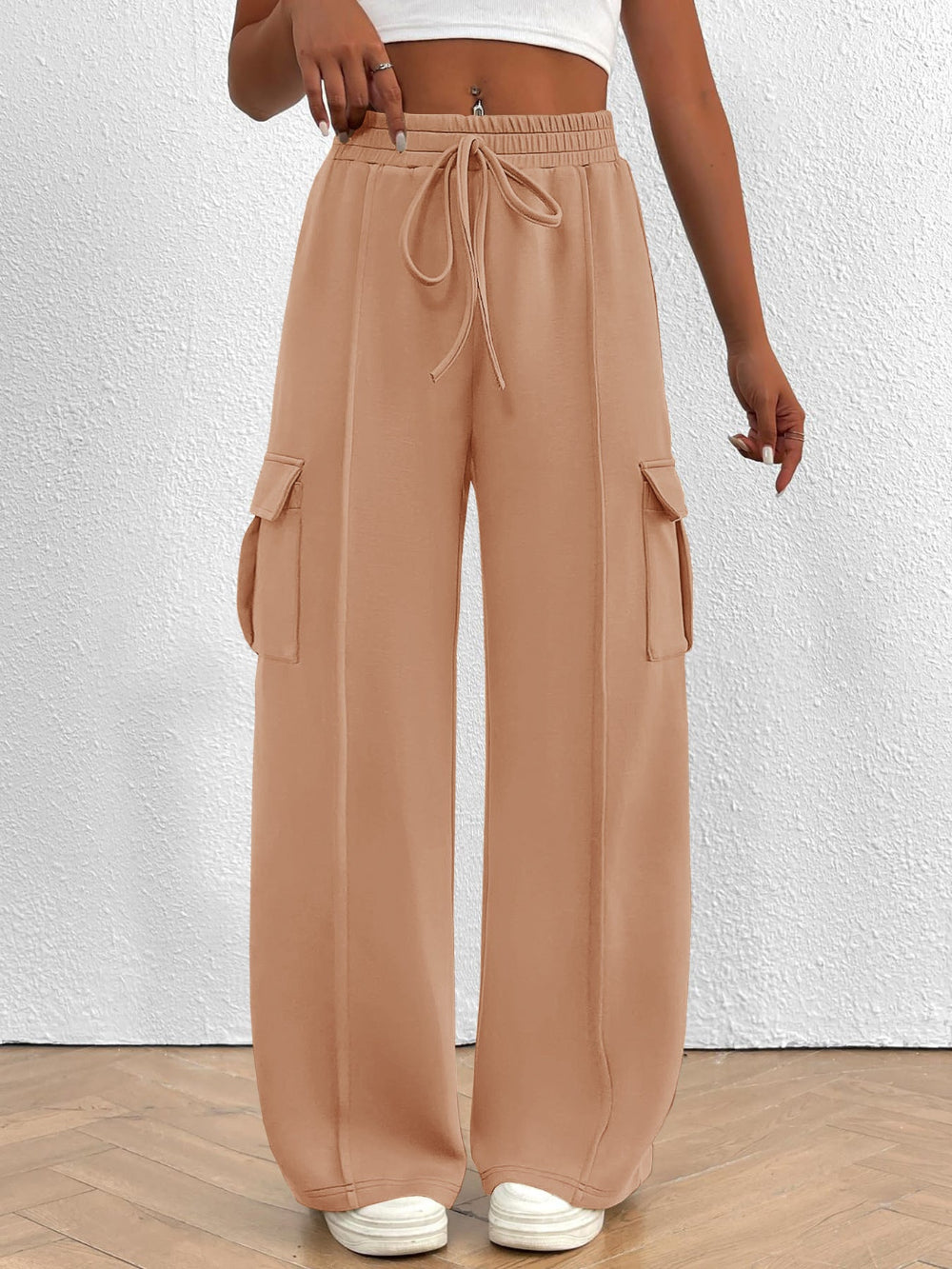 Tan wide-leg pants with drawstring waist and pocket details on a white background
