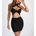 "Woman with long wavy hair wearing a black bodycon mini dress featuring a halter neck with criss-cross straps, large front cut-out at the waist, and ruched skirt, posing with one hand near her face against a plain white background."