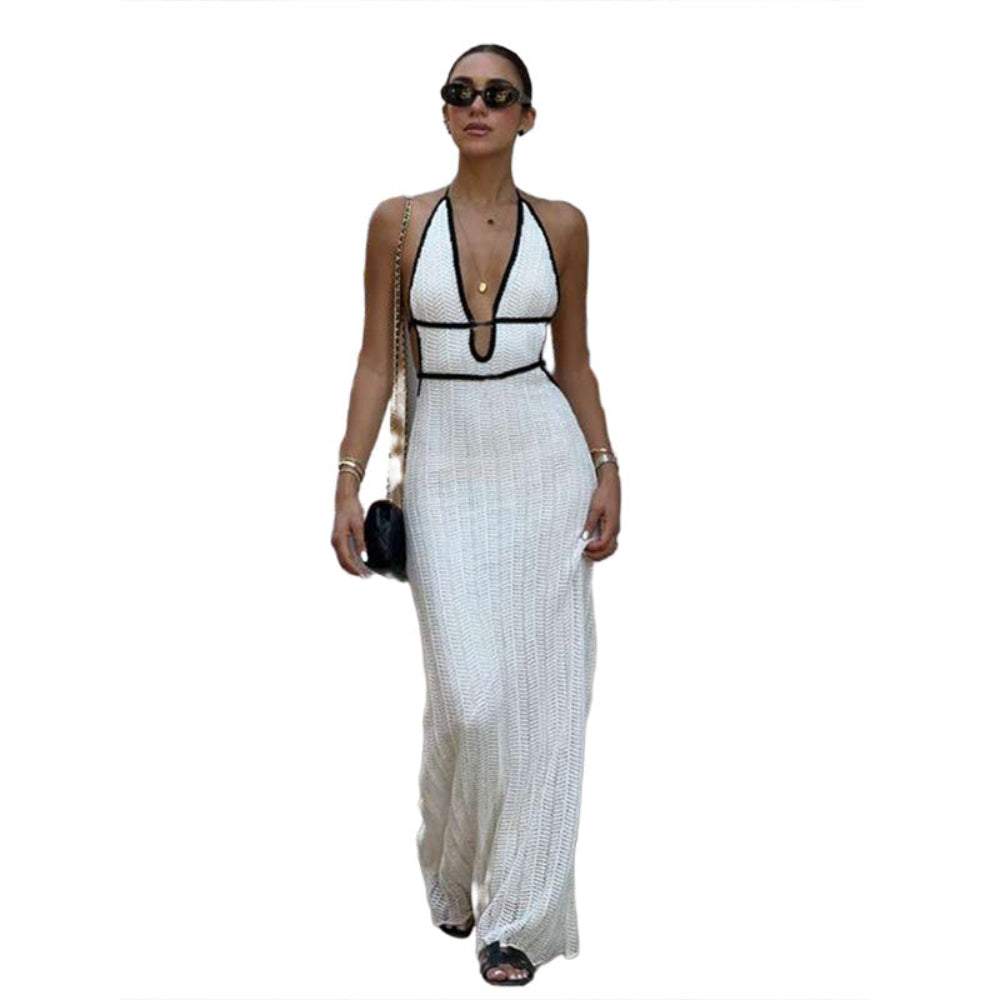 Model wearing white ribbed knit halter maxi dress with black contrast trim and plunge cutout, accessorized with sunglasses and handbag.