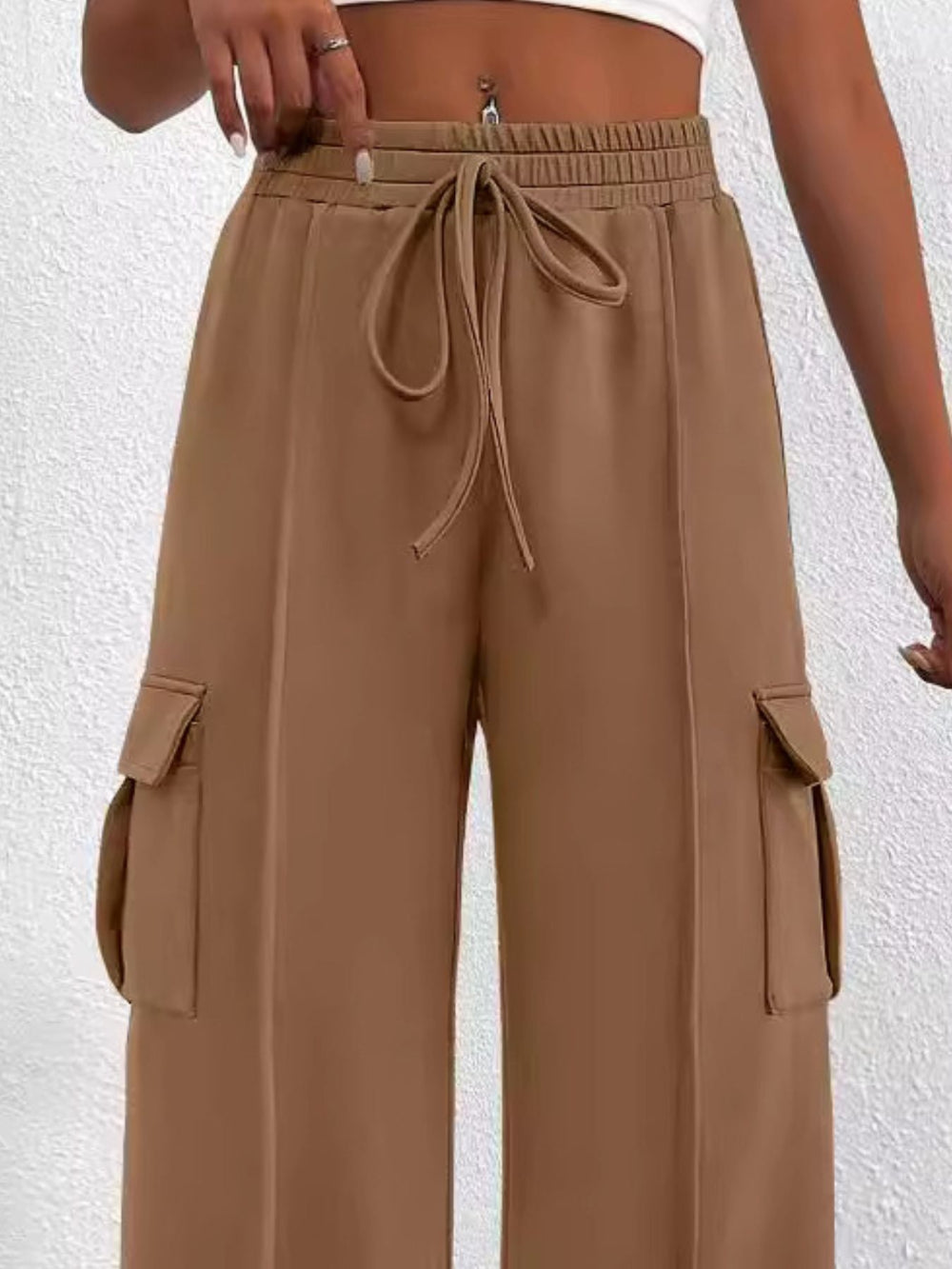 Brown cargo pants with a drawstring waist on a white background