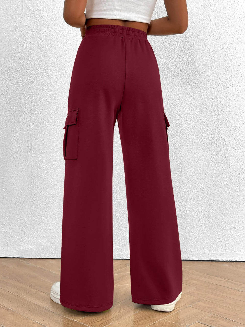 Maroon cargo pants worn by a person on a white background