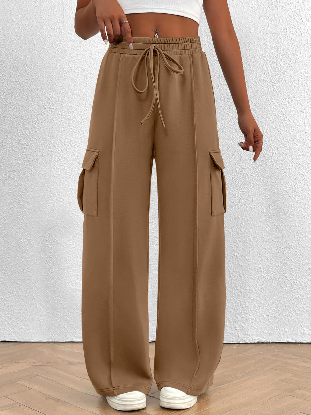 Brown cargo pants worn by a person on a white background