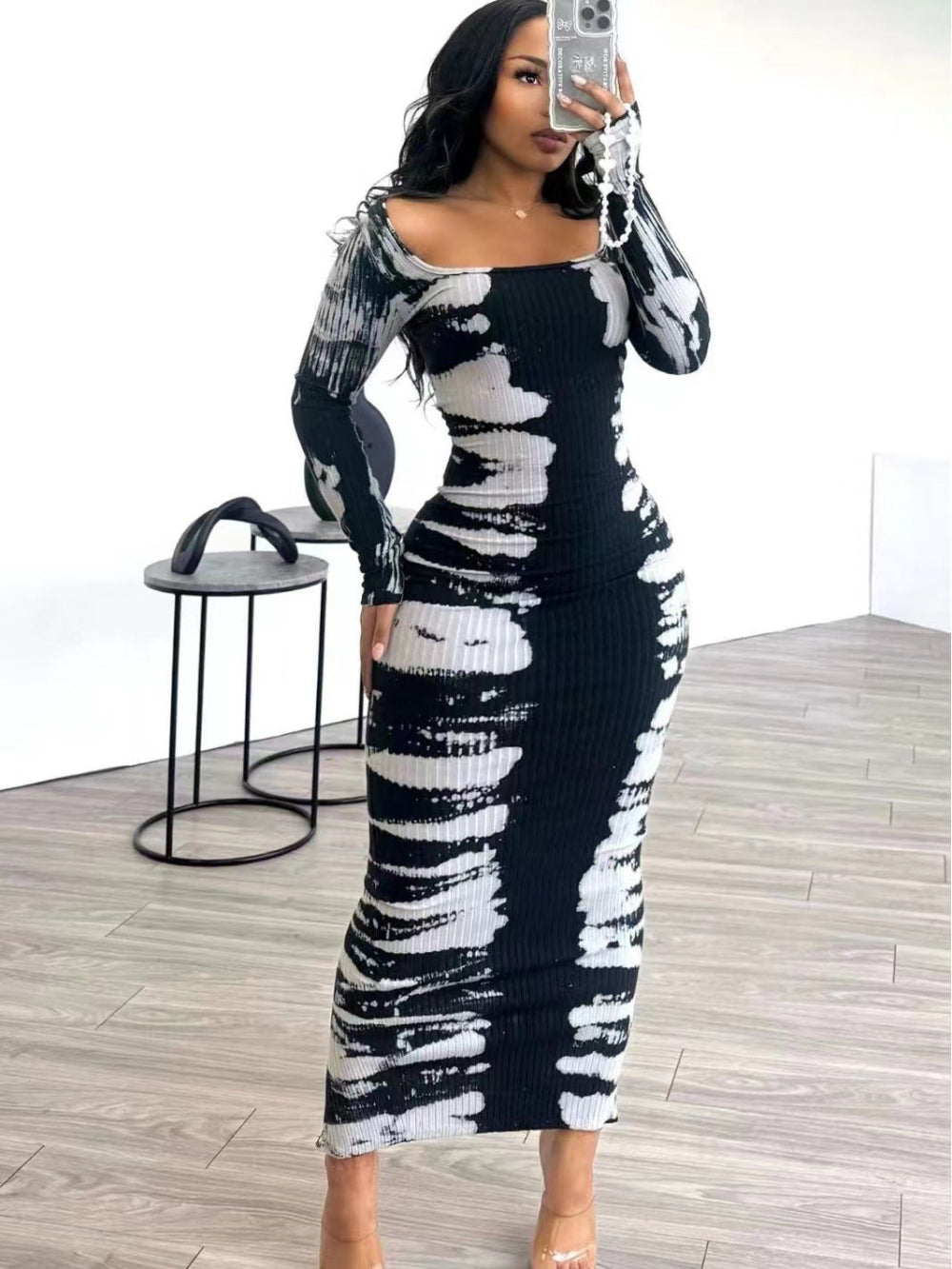 Woman taking mirror selfie in black and white tie-dye ribbed long-sleeve bodycon midi dress with off-shoulder neckline.