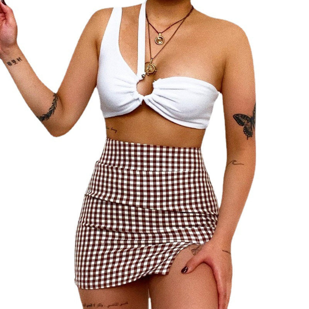 White ring-front ruched bralette paired with a brown and white gingham mini skirt, worn by a model with tattoos and layered necklaces.