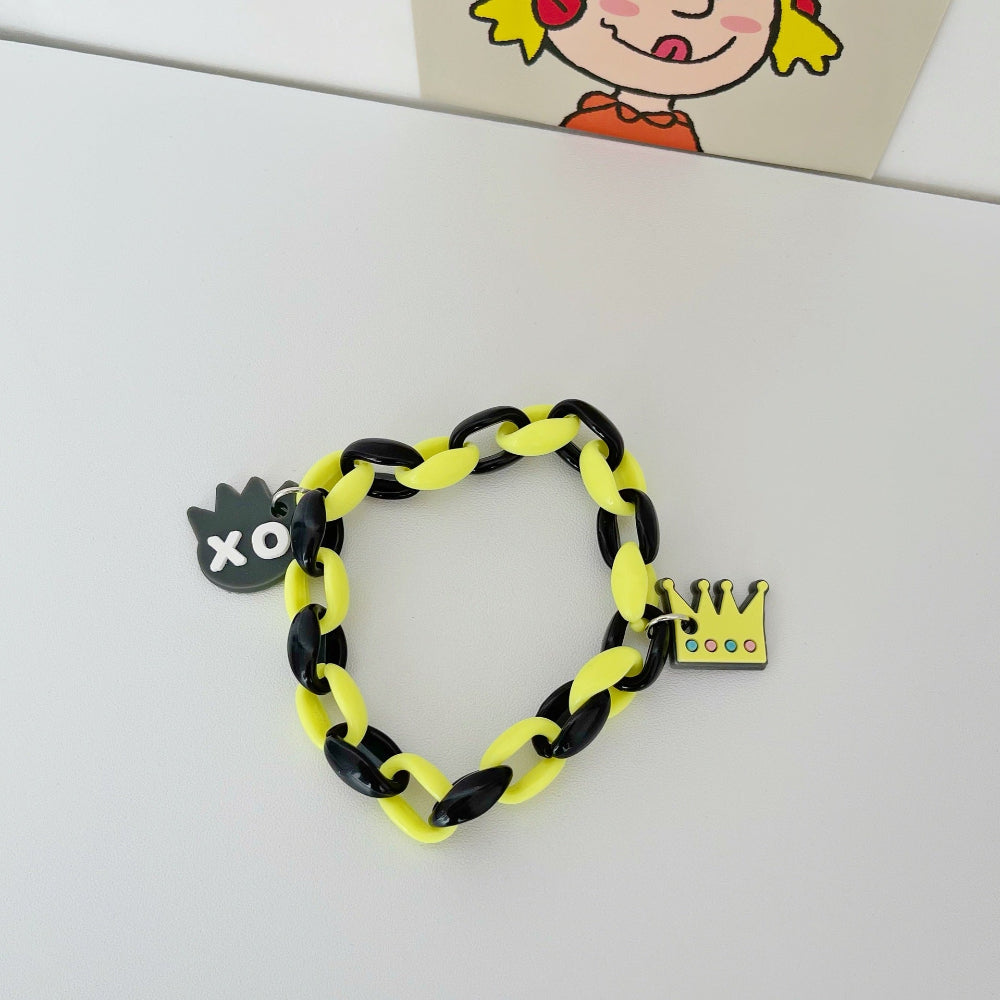 Bold black and bright yellow link chain bracelet featuring a black cloud "XO" charm and a yellow crown charm with multicolored gemstones