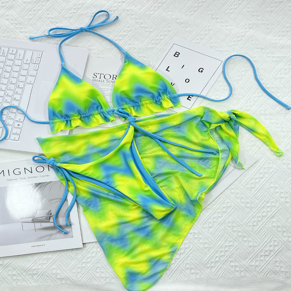 Tie-dye bikini set with blue and green colors on a textured surface.