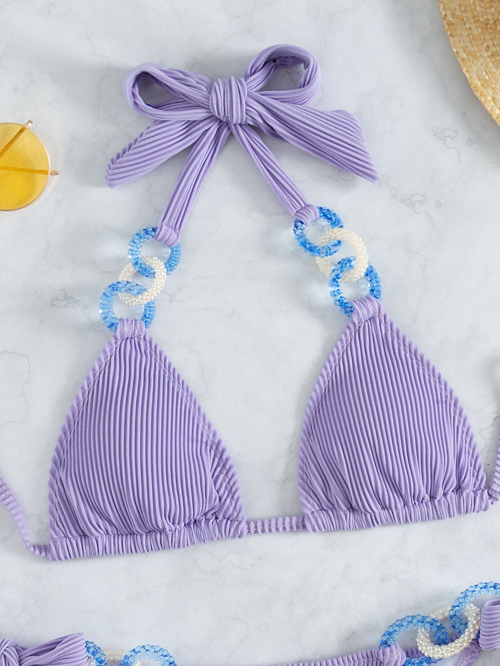 Lavender pleated halter bikini top with bow tie and shell chain detail close-up.