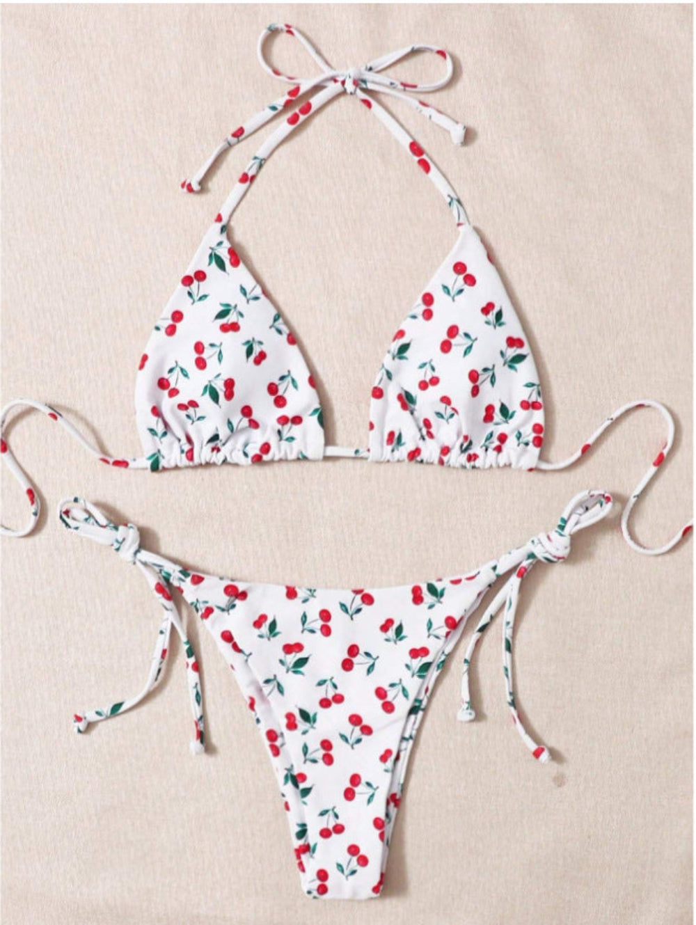 Cherry print bikini set with triangle halter top and tie-side bikini bottom.