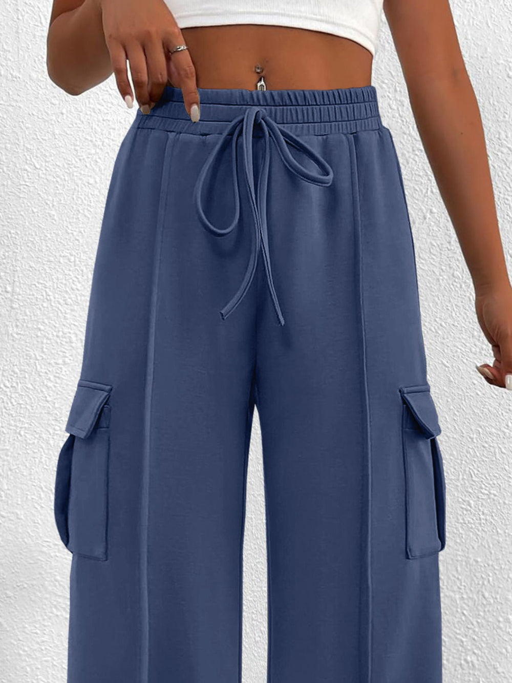 Blue cargo pants with a drawstring waist on a white background