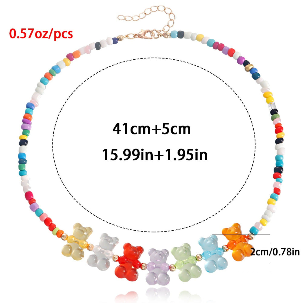 Rainbow beaded choker necklace with multicolored seed beads and a row of vibrant translucent gummy bear charms in yellow, white, red, purple, green, blue, and orange. Features a gold clasp with 5cm extender (total 41cm+). Fun, colorful statement piece with detailed measurements shown.