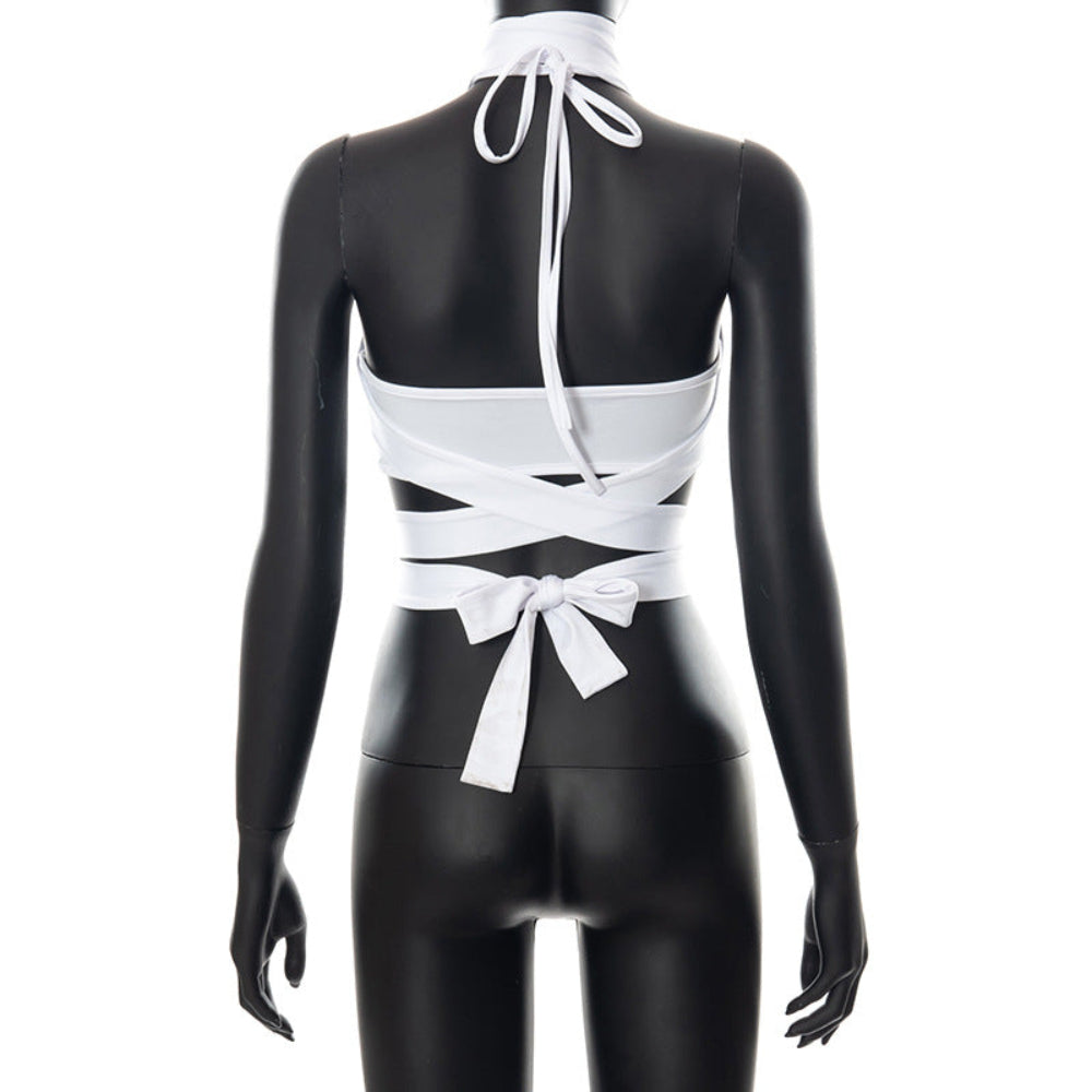 Alt text: Back view of a black mannequin wearing the white halter crop top, featuring adjustable neck ties, dramatic crisscross wrap straps across the back, and a sweet bow tie closure at the waist, showcasing the stylish, adjustable, and flattering design.
